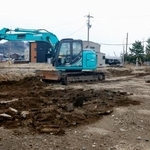 　朝市通り周辺でがれきを撤去する重機＝２６日午前、石川県輪島市