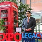 　大阪・関西万博の英国パビリオン前に設置されていた赤い「電話ボックス」前であいさつする関西エアポートの山谷佳之社長＝２７日午前、関西空港