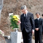 　御嶽山噴火災害の慰霊碑と山頂に向かって黙とうする気象庁の野村竜一長官（手前）＝２８日午後、長野県王滝村