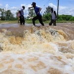 　ケニア西部で、豪雨で冠水した道路を渡る人々＝２４日（ＡＰ＝共同）