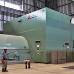 　営業運転を開始した「ひびき発電所」のタービン建屋に置かれたガスタービン（右）と発電機＝３月２４日、北九州市