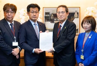 　仁木博文厚労副大臣（中央左）に要望書を手渡す、全国がん患者団体連合会の天野慎介理事長（同右）＝１日午後、厚労省