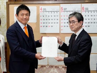 　日本国旗損壊行為への刑罰を明記した刑法改正案を伊藤文靖参院事務総長（右）に提出する参政党の神谷代表＝２日午後、国会