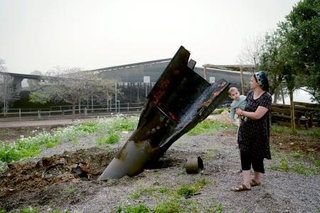 　ヨルダン川西岸のユダヤ人入植地で、イランから発射され着弾した弾道ミサイルを見るイスラエル人女性＝３日（ゲッティ＝共同）