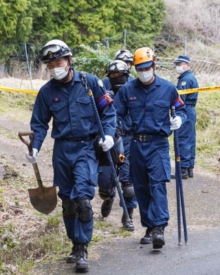 　捜索現場の山林から出る京都府警の警察官＝９日午後、京都府南丹市
