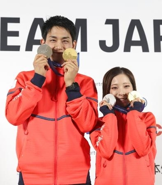 　メダルを手にポーズをとる三浦璃来（右）、木原龍一組＝２月１７日、イタリア・ミラノ（共同）