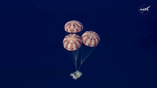　パラシュートを開き、米西部カリフォルニア州沖に着水する宇宙船オリオン＝１０日（ＮＡＳＡの中継から）