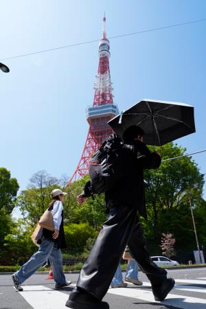 　今年初の夏日となった東京都心部で、日傘を差して歩く人＝１１日午後、東京都港区