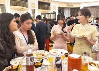 　中国人学生と会話を楽しむチャイナドレス姿で参加した日本の留学生＝１１日、中国上海市（共同）