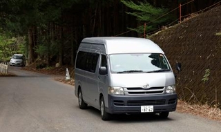　山中で発見された遺体を運び出す大分県警の車両＝１２日午後４時１４分、大分県豊後大野市