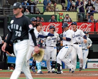 　１０回、サヨナラ本塁打を放ちチームメートに迎えられる西武・林安可（右から２人目）。手前は打たれたロッテのロング＝ベルーナドーム