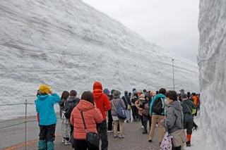 　「立山黒部アルペンルート」が全線開通し、「雪の大谷ウオーク」を楽しむ観光客＝１５日午前、富山県立山町