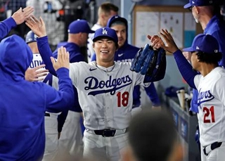 　メッツ戦の７回を投げ終え、ベンチで迎えられるドジャース・山本＝ロサンゼルス（共同）