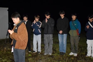 　東海大生が犠牲になったアパート倒壊現場で手を合わせる卒業生の橋村さくらさん（左端）と現役学生ら＝１６日未明、熊本県南阿蘇村