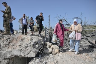 　イスラエルの攻撃で破壊された橋を渡ろうとする人々＝１６日、レバノン南部スール近郊（ゲッティ＝共同）