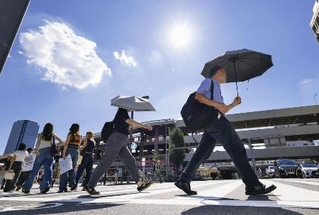　昨年８月、最高気温４０度を観測した名古屋市で日傘を差して歩く人たち