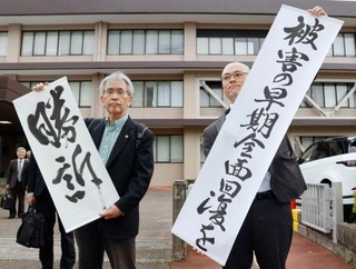 　生活保護減額訴訟の控訴審判決後、「勝訴」などと書かれた垂れ幕を掲げる弁護士ら＝１７日午後、福岡高裁宮崎支部前