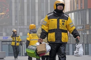 　北京市内の繁華街で働く出前アプリ「美団」の配達員＝２０２５年１２月（共同）