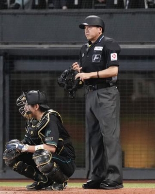 　頭部にバットが直撃し審判員が負傷したことを受け、ヘルメットをかぶる運用が始まった日本ハム-西武戦の球審＝１８日、エスコンフィールド北海道
