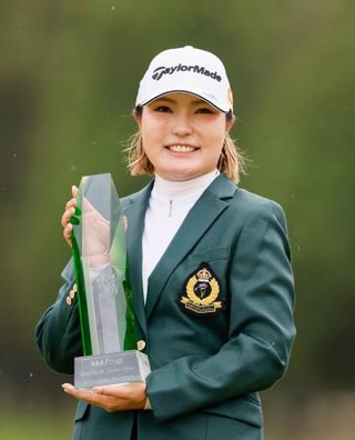 　通算１４アンダーで優勝し、トロフィーを手に笑顔の高橋彩華＝熊本空港ＣＣ