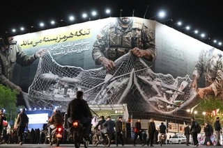 　イランの首都テヘランに掲げられた、ホルムズ海峡掌握による米イスラエルへの徹底抗戦を訴える看板＝２１日（共同）