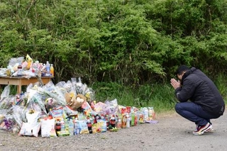 　安達結希さんの遺体が遺棄された現場付近で手を合わせる人＝２２日午後、京都府南丹市