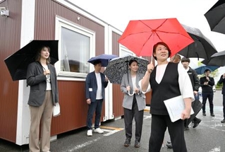 　アジア・アジアパラ大会で選手の宿泊拠点となる仮設のコンテナハウスを視察する谷本歩実アスリート委員長（手前右）ら＝２３日午前、名古屋市