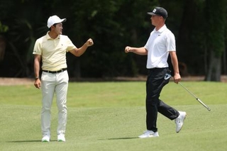 　チューリッヒ・クラシック第１ラウンド、１０番でウィリアム・マウと拳を突き合わせる金谷拓実＝２３日、ルイジアナ州エーボンデール（ゲッティ＝共同）