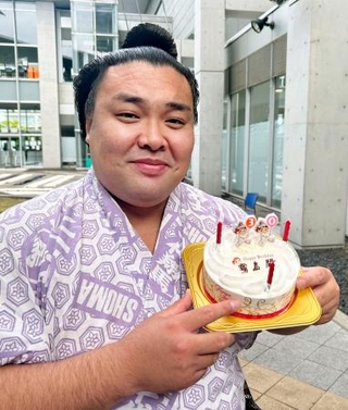 　３０歳の誕生日を迎え、報道陣から贈られたケーキを手に笑顔の霧島＝２４日、さいたま市
