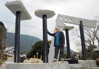 　「旧金毘羅大芝居」（左後方）の鉄柱を使いモニュメントを作った篠原勝之さん＝２００５年３月、香川県琴平町