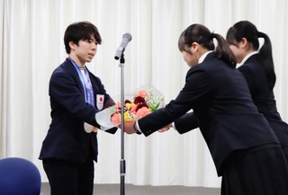 　母校の埼玉栄高でミラノ・コルティナ冬季五輪の報告会を行い、花束を贈られるフィギュアスケート男子の佐藤駿＝２７日、さいたま市