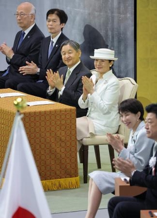 　昭和元年から１００年を記念する式典で、音楽隊による演奏に拍手される天皇、皇后両陛下。右から２人目は高市首相＝２９日午後、東京・日本武道館（代表撮影）