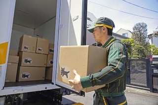 　車両から荷物を取り出すヤマト運輸の配達員（同社提供）