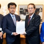 　仁木博文厚労副大臣（中央左）に要望書を手渡す、全国がん患者団体連合会の天野慎介理事長（同右）＝１日午後、厚労省