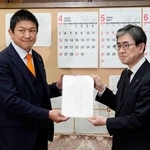 　日本国旗損壊行為への刑罰を明記した刑法改正案を伊藤文靖参院事務総長（右）に提出する参政党の神谷代表＝２日午後、国会