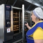 　２日、キーウの学校で、日本が供与したオーブンを使う調理担当者（共同）