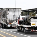 　事故があった新名神高速下り線の野登トンネルから運び出された焼けたトラックと車両（荷台上）＝３月２０日、三重県菰野町