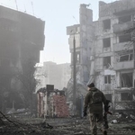 　ロシア軍の攻撃を受けた住宅近くを歩くウクライナ兵＝３月、ウクライナ南部ザポリージャ州オリヒウ（ロイター＝共同）