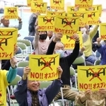 　集会で「ＮＯ！！オスプレイ」と書かれたプラカードを掲げる参加者＝５日午後、佐賀市