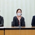 　記者会見する小金澤昇さんの妻恵美理さん（中央）と代理人弁護士＝６日午後、厚労省