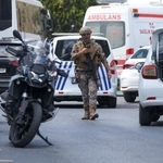 　銃撃事件の現場付近を歩く警察官ら＝７日、トルコ・イスタンブール（ロイター＝共同）