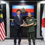 　マレーシア軍に対し監視用機材を供与する引き渡し式で関係者と握手する四方敬之駐マレーシア日本大使（左）＝８日、クアラルンプール（共同）