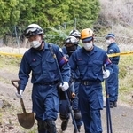 　捜索現場の山林から出る京都府警の警察官＝９日午後、京都府南丹市