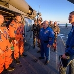 　地球に帰還し、米軍の船上でＮＡＳＡのアイザックマン長官（右端）と話すワイズマン飛行士（左端）とハンセン飛行士（左から２人目）＝１０日（ＮＡＳＡ提供）