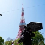 　今年初の夏日となった東京都心部で、日傘を差して歩く人＝１１日午後、東京都港区