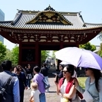 　今年初の夏日となった東京都心部で日傘を差して歩く人たち＝１１日午後、東京都港区