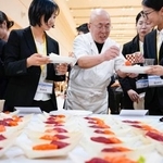 　ＪＥＴプログラムの壮行会で寿司を手にする参加者ら＝１１日、北京の日本大使館（共同）