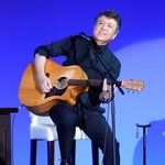 　自民党大会に特別ゲストとして登場し、弾き語りする音楽家の世良公則さん＝１２日午前、東京都内