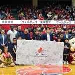 　試合後に記念撮影するバスケットボールＢ２熊本の選手とＯＢら＝１２日、熊本県立総合体育館