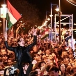 　ハンガリー議会総選挙の結果を受け、国旗を振って喜ぶ男性ら＝１２日、ブダペスト（ＡＰ＝共同）